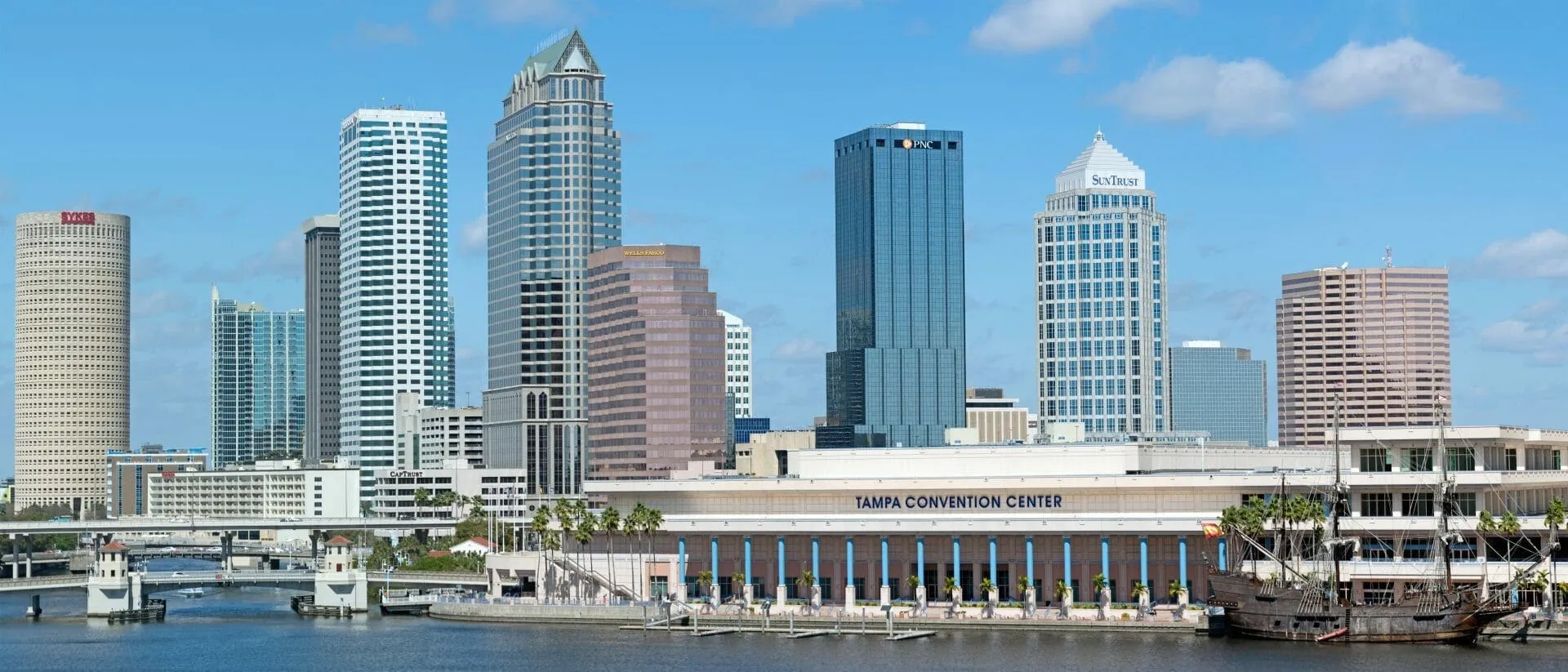 A city skyline with tall buildings and a river.