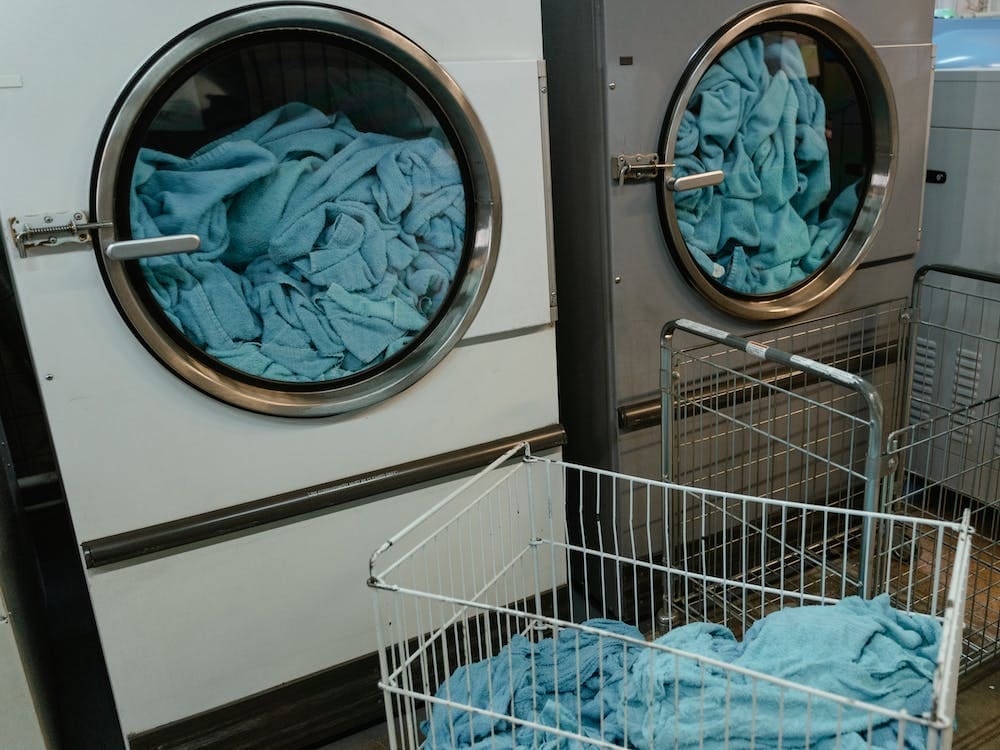 A laundry room with blue towels in a basket.
